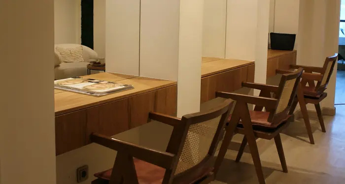 Wooden counters and cane chairs under white arches.